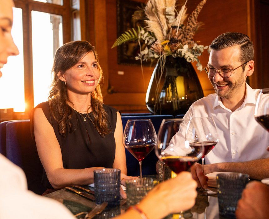Gäste genießen ein Glas Wein in der stilvollen Umgebung von Schloss Montfort.