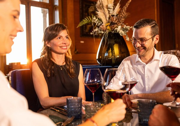 Gäste genießen ein Glas Wein in der stilvollen Umgebung von Schloss Montfort.